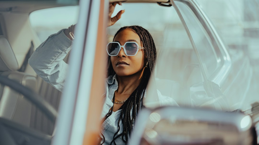 Mulher sentada ao volante olhando pela janela do carro